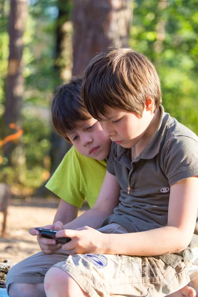 Kind spelen telefoon buitenshuis — Stockfoto