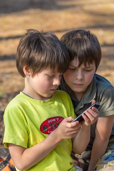 Child playing phone outdoors — Stock Photo, Image