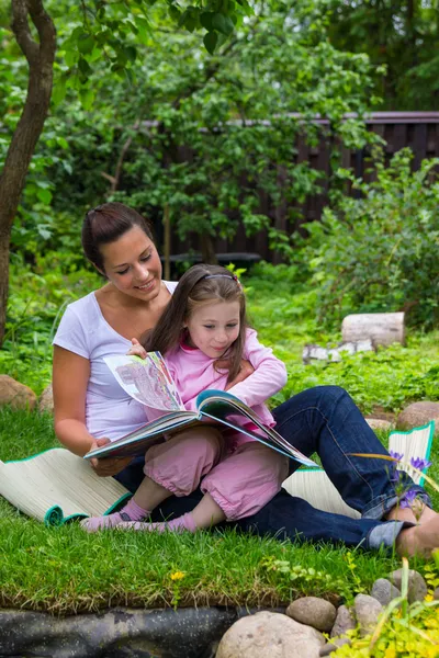 Mutter und Tochter lesen Buch im Freien — Stockfoto