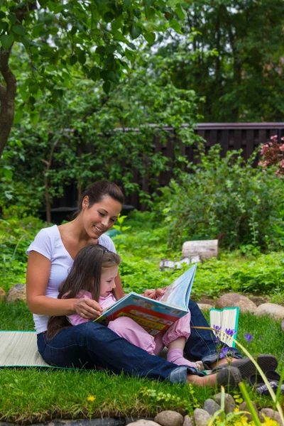 Mutter und Tochter lesen Buch im Freien — Stockfoto