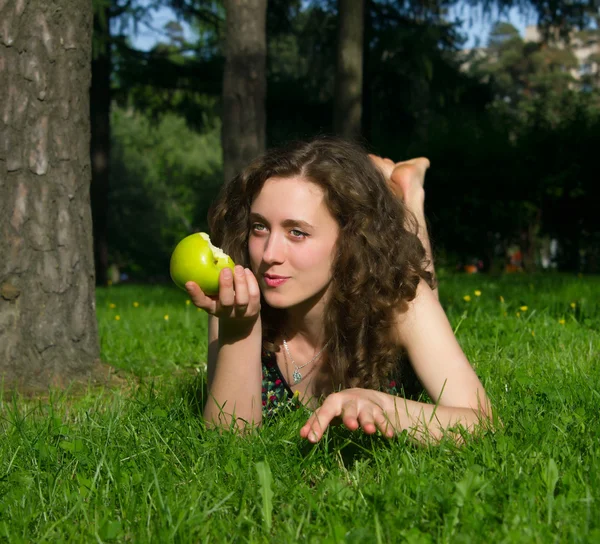 Bella giovane donna mangiare mela all'aperto — Foto Stock