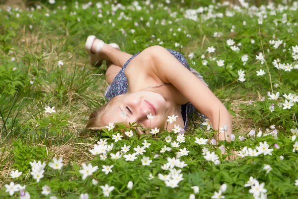 Jovem mulher loira bonita em um prado flores — Fotografia de Stock