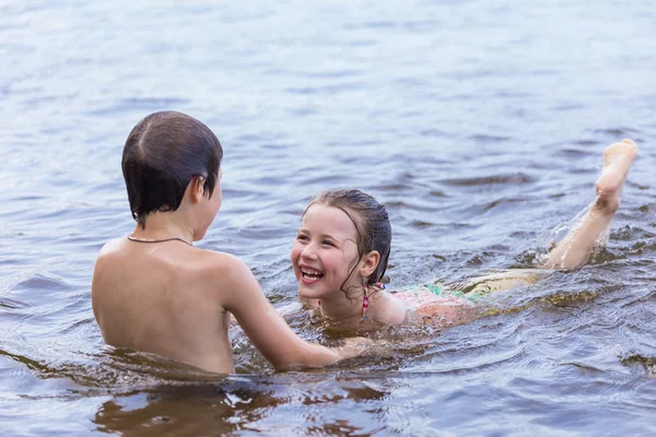 Chlapeček učí svou malou sestru plavat — Stock fotografie