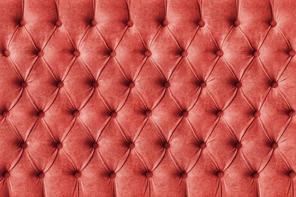 Red capitone checkered soft fabric textile decorative background with buttons. Classic retro Chesterfield style, luxurious upholstery buttoned texture for furniture, wall, headboard, sofa, couch