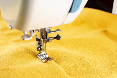 Modern sewing machine presser foot with linen fabric and thread, closeup, copy space. Sewing process clothes, curtains, upholstery. Business, hobby, handmade, zero waste recycling repair concept, DIY