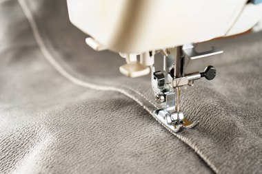 Modern sewing machine presser foot with linen fabric and thread, closeup, copy space. Sewing process clothes, curtains, upholstery. Business, hobby, handmade, zero waste recycling, repair concept, DIY