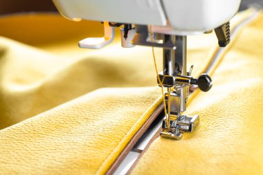 Modern sewing machine special presser foot and zipper with yellow fabric. Sewing process clothes, curtains, upholstery. Business, hobby, handmade, zero waste recycling repair concept, DIY, copy space