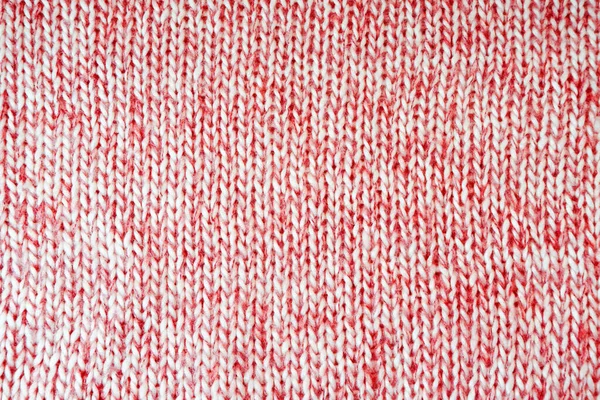 Close up background of knitted wool fabric with dots pattern. Mixed white red color wool knitwear texture. Openwork abstract knitted jersey. Fabric abstract backdrop