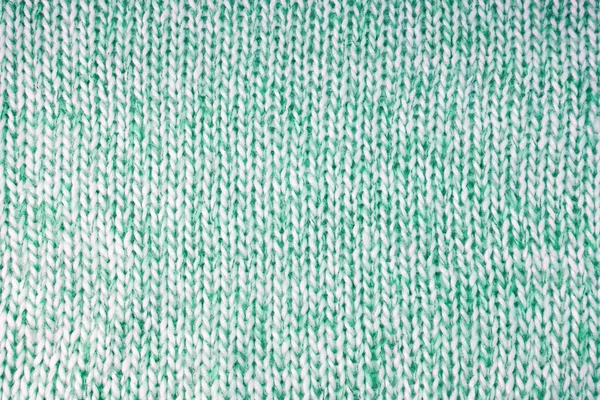 Close up background of knitted wool fabric with dots pattern. Bright green color wool knitwear texture. Openwork abstract knitted jersey. Fabric abstract backdrop