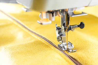 Modern sewing machine special presser foot and zipper with yellow fabric. Sewing process clothes, curtains, upholstery. Business, hobby, handmade, zero waste recycling repair concept, DIY, copy space