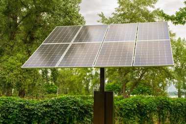 Solar panels in public park backgound. Photovoltaic modules for renewable energy, system of electric generators from the sun. Clean technologies, green and renewable energy, eco friendly electricity
