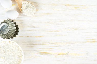 Baking cooking Ingredients background with copy space. Flour, eggs, milk, bakeware on white wooden surface. Top view, flat lay. Mockup menu, banner, header for site, baking concept
