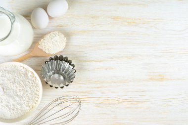 Baking cooking Ingredients background with copy space. Flour, eggs, milk, bakeware on white wooden surface. Top view, flat lay. Mockup menu, banner, header for site, baking concept