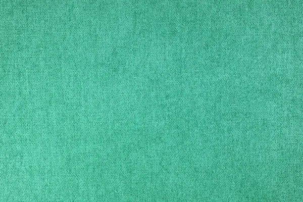 Texture background of velours turquoise fabric. Fabric texture of upholstery furniture textile material, design interior, wall decor. Fabric texture close up, backdrop, wallpaper.