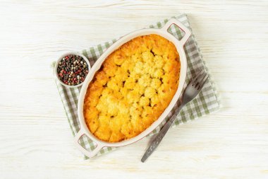 Shepherd 's Pie mı, Cottage Pie mı? Kıyma, patates püresi ve sebze güveci beyaz ahşap arka planda. Geleneksel İngiliz, Birleşik Krallık, İrlanda mutfağı. Üst manzara, düz uzanma