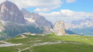 Dolomite dağlarının bir kısmının panoramik görüntüsü. Bazı kaya kuleleri yeşil bir çayırda ve mavi bir gökyüzünde duruyor. panoramik kamera hareketi