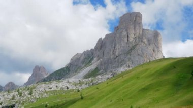 Dolomite dağlarının bir kısmının panoramik görüntüsü. Bazı kaya kuleleri yeşil bir çayırda ve mavi bir gökyüzünde duruyor. panoramik kamera hareketi