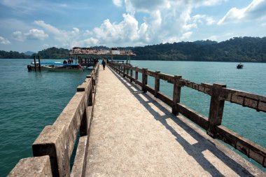 Pulau Beras Basah, Langkawi, Malezya 'dan Jetty. Pulau Beras Basah Adası, Langkawi 'de, açık mavi gökyüzü ve suyla uzun Jetty' nin güzel manzarasında ziyaretçiler veya turistler tanımlanıyor.,