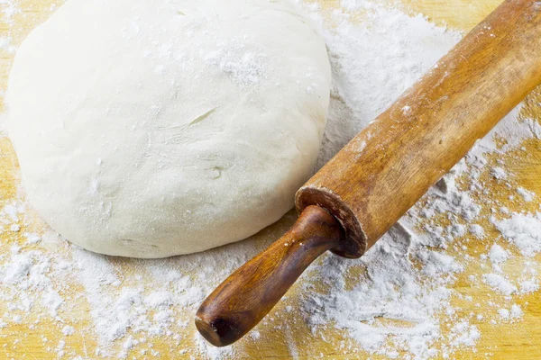 Rolling pin with pizza dough — Stock Photo, Image
