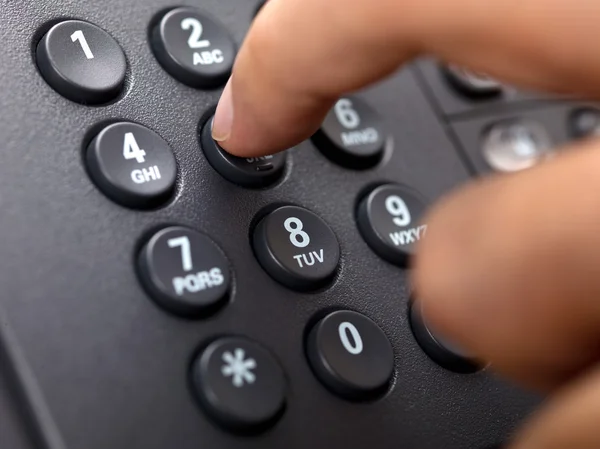 Close up shot of human finger pressing landline phone number — Stock Photo, Image
