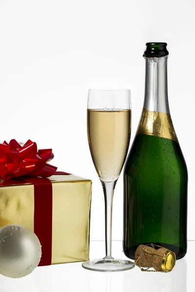 Champagne flute and bottle with christmas gift — Stock Photo, Image