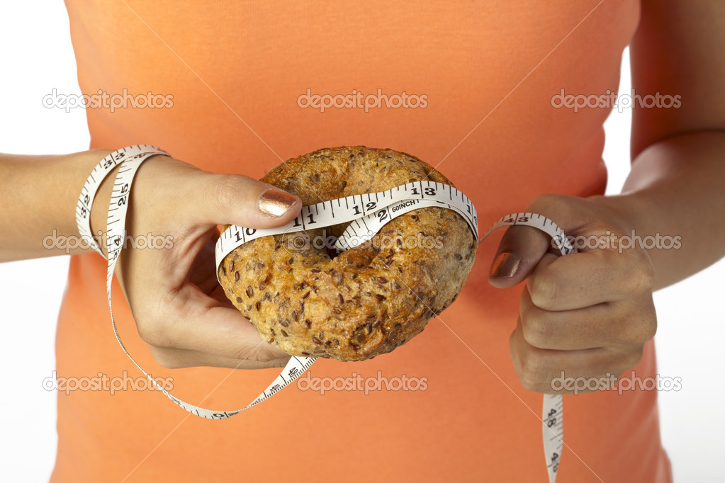 Hand holding bread with measuring tape