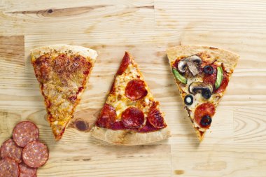 ahşap yüzey üzerinde üç pişmiş pizza pasta