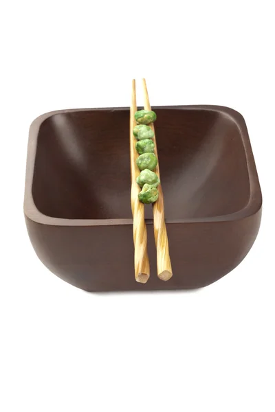 Chopsticks on a wooden bowl with green pies — Stock Photo, Image
