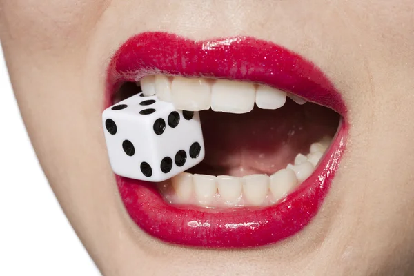 Woman biting dice — 图库照片