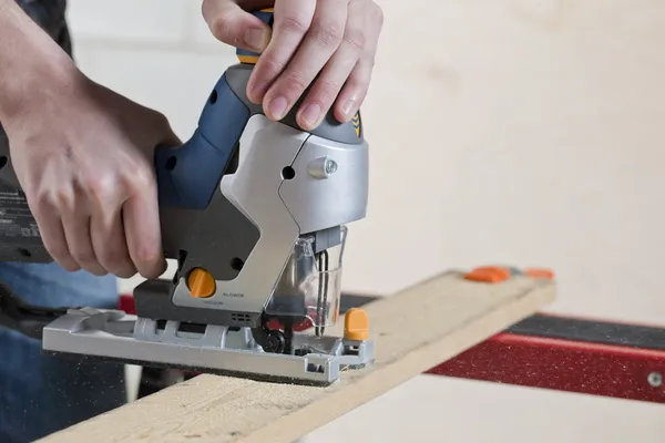 Man een stuk hout snijden — Stockfoto