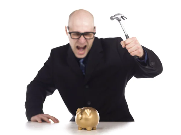 Homem de negócios careca quebrando banco porquinho dourado com martelo — Fotografia de Stock