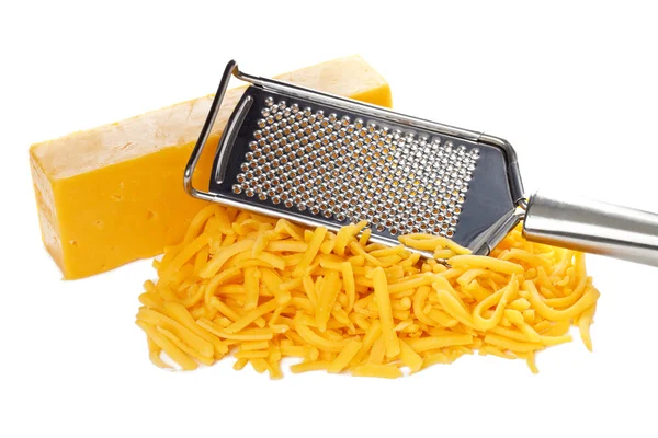 Grated bar of cheddar cheese and metal grater — Stock Photo, Image