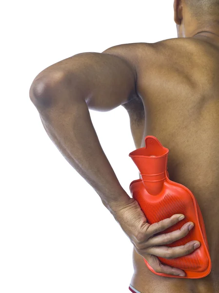 Chico colocando bolsa de agua caliente en su espalda — Foto de Stock