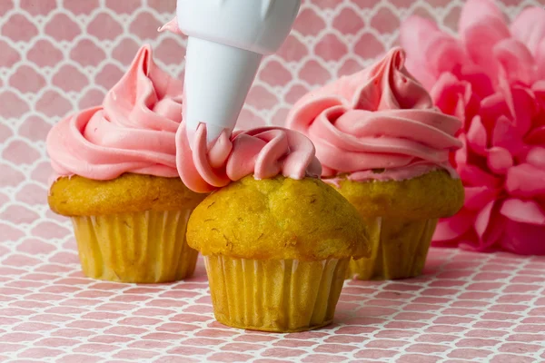 Slagroom toe te passen op cupcakes — Stockfoto