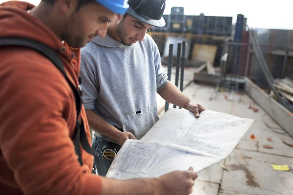 Architecten kijken naar werkplan — Stockfoto