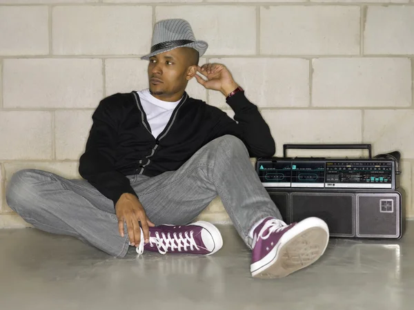 Attractive guy sitting on the floor with a boom box — Stock Photo, Image