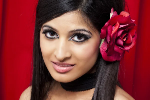 Attractive indian female fashion model wearing a rose in her hai — Stock Photo, Image