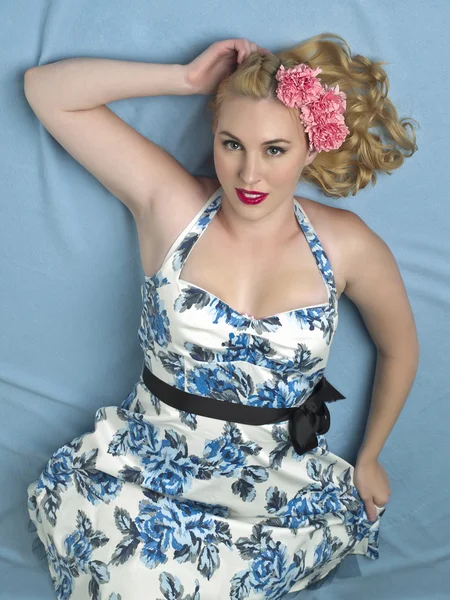 Beautiful woman lying on back with a flower on hair — Stock Photo, Image