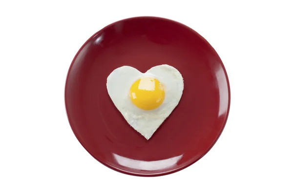 Жареное яйцо в форме сердца подается в тарелке — стоковое фото