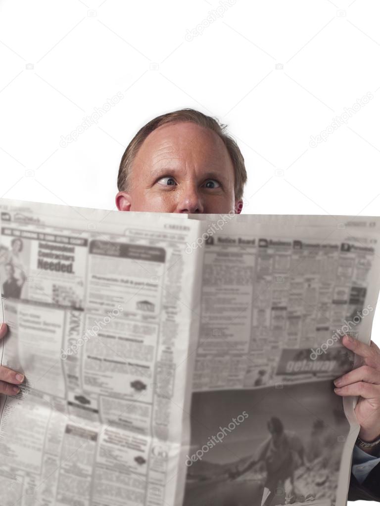 front view of a businessman holding newspaper with eyes cocked