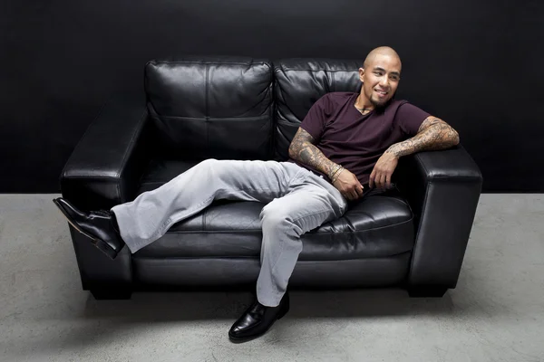 Happy african american man relaxing on couch — Stock Photo, Image