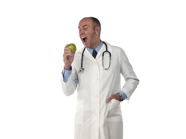 Mature doctor holding apple with mouth open — Stock Photo, Image