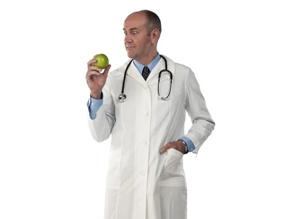 Mature doctor looking at green apple — Stock Photo, Image