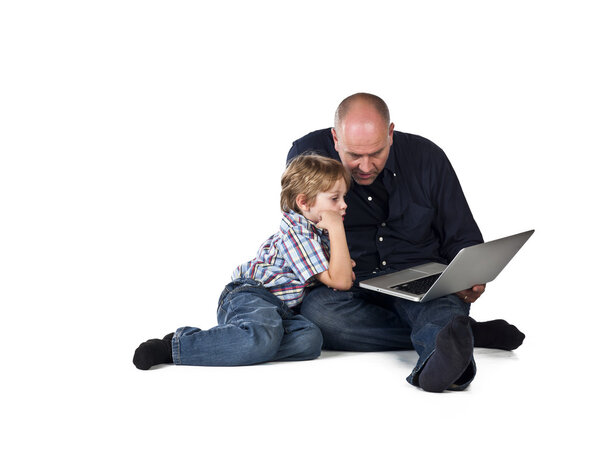 mid adult and and his son using laptop