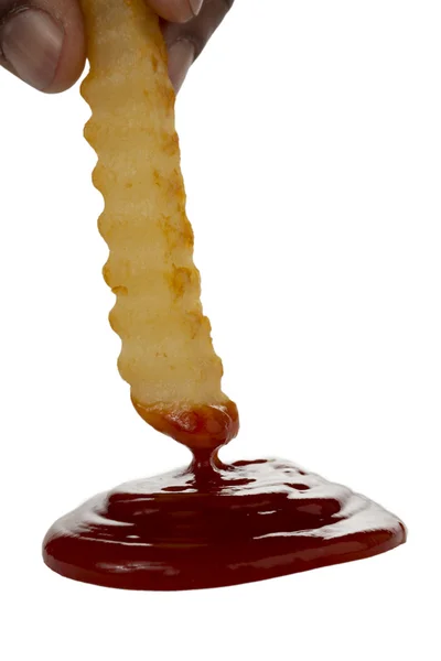 Dipping fried potato into ketchup — Stock Photo, Image