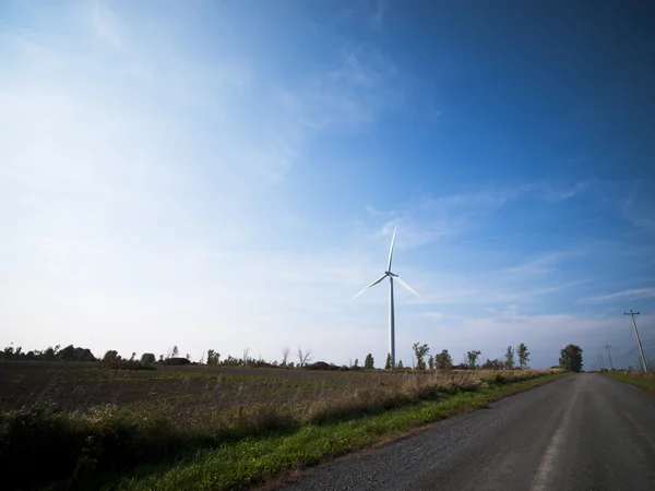 Empty road with wind mill in the background — Stock Photo, Image