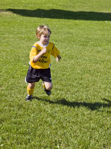 Little soccer player running in field — Stock Photo, Image