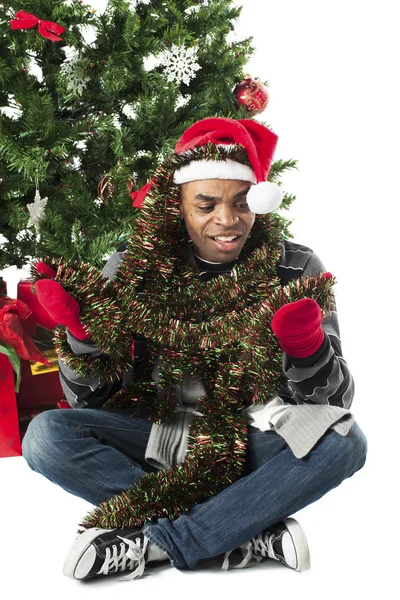 Człowiek zawinięty w Boże Narodzenie dekoracje — Zdjęcie stockowe
