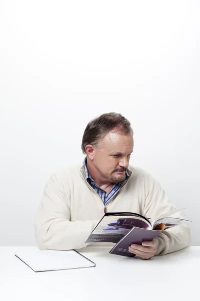 Mature businessman reading a magazine — Stock Photo, Image