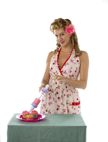 Retrato de uma jovem mulher sorridente decorando cupcakes — Fotografia de Stock